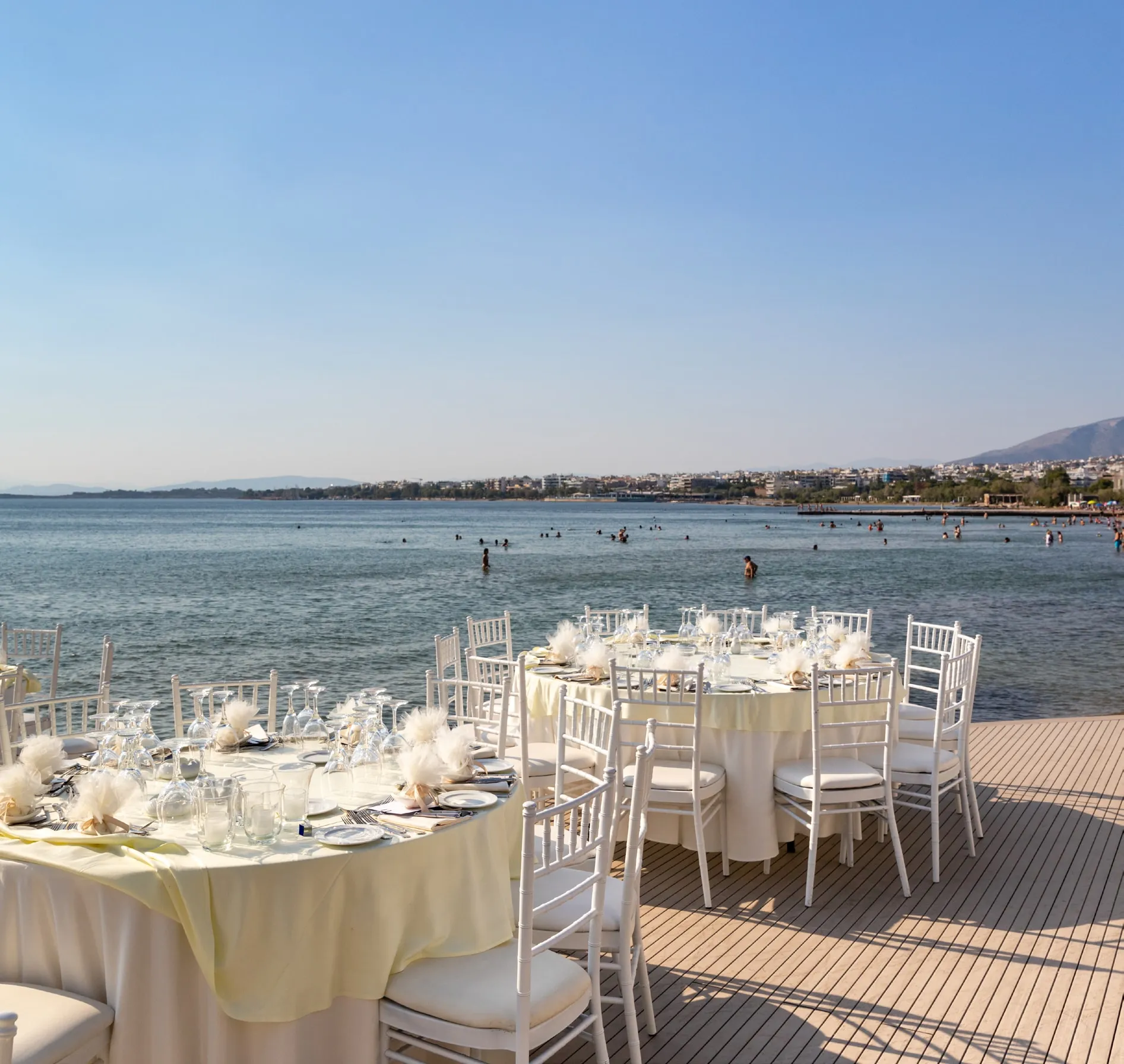 Tables laid on a deck over the sea at Vouliagmeni